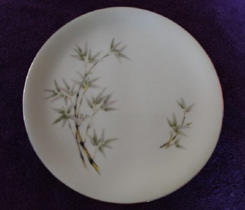 A white plate with green leaves on it.