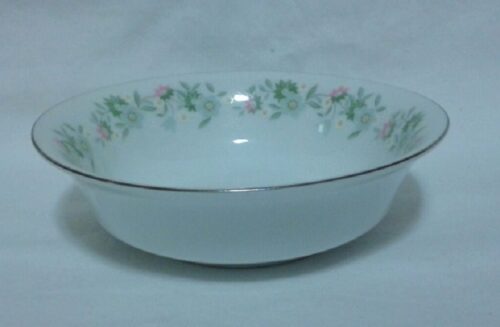 A bowl with flowers on it is sitting on the table.