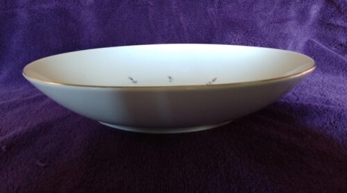A bowl with a purple background and some white bowls