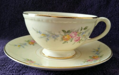A white cup and saucer with flowers on it.