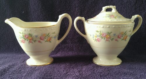 A white and pink floral pattern sugar bowl and creamer.