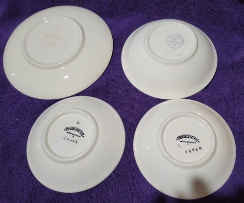 Four white plates with a purple background