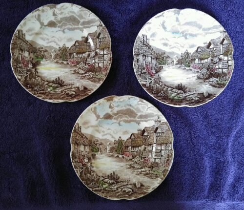 Three plates with a landscape on them are sitting on the table.