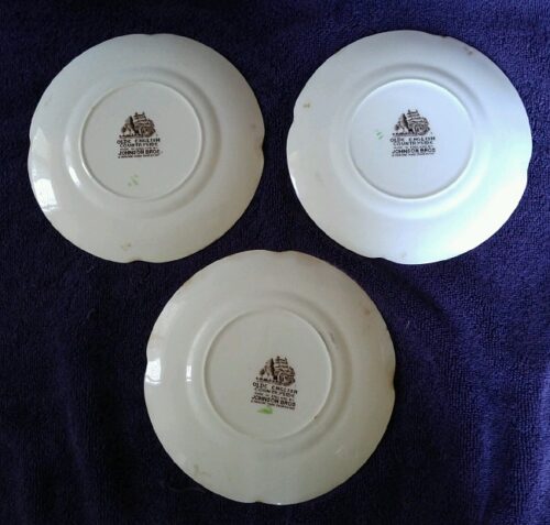 Three plates with a logo on them are sitting on the table.