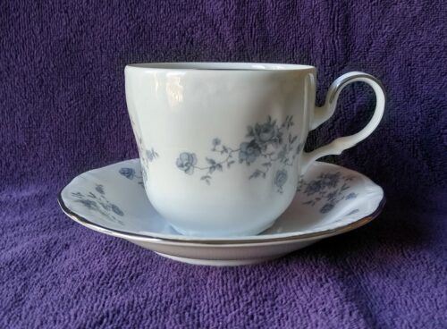 A cup and saucer on purple cloth
