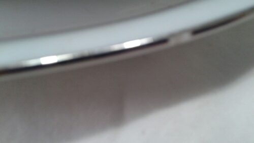 A close up of the edge of a white plate