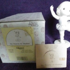A white figurine is sitting in front of the box.