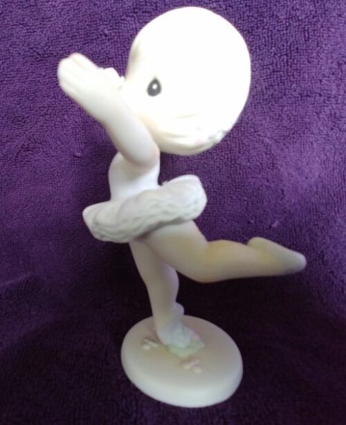 A white figurine of a person in a pose.