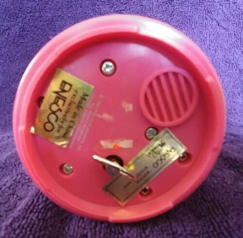 A pink plastic container with some gold stickers on it