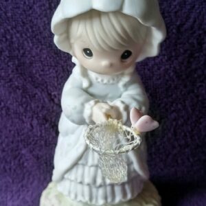 A figurine of a girl holding a basket.
