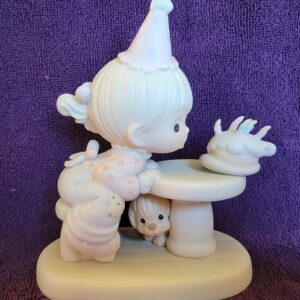 A white figurine of a girl with a cat.