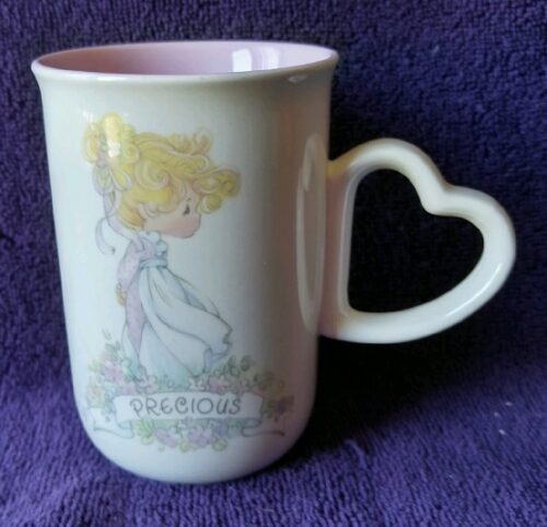 A cup with a heart shaped handle and a picture of a girl.