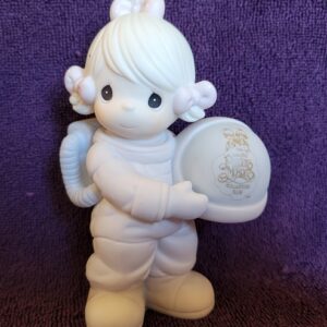 A white angel figurine holding an object in her hands.