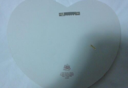 A white heart shaped plate with the words " unwrapped ".