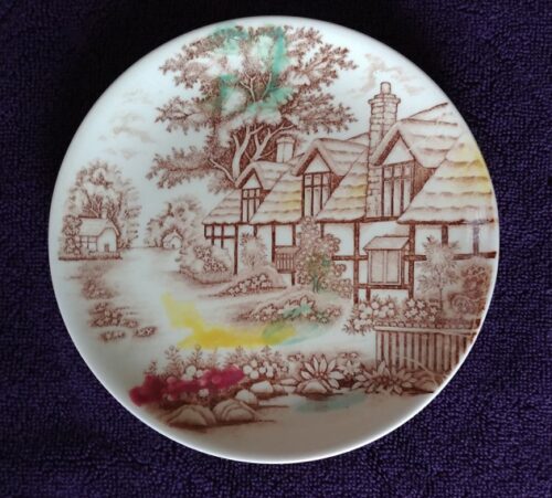 A plate with a picture of a house on it.
