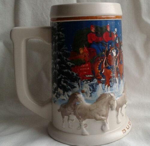 A beer mug with horses and carriages on it.