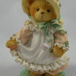 A teddy bear wearing a dress and hat.