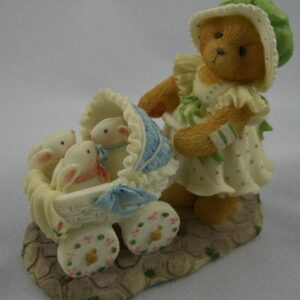 A teddy bear with a baby carriage and a stuffed animal.