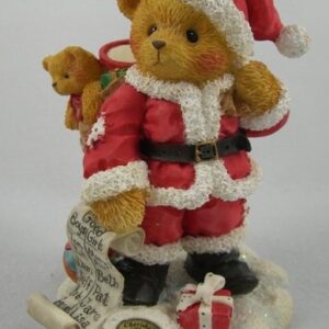 A bear wearing santa 's outfit and holding a present.