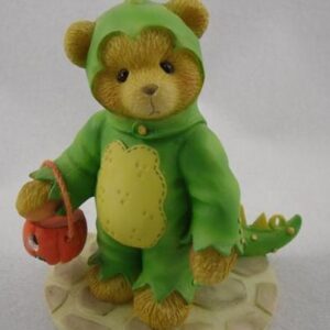 A teddy bear in green outfit holding an apple.