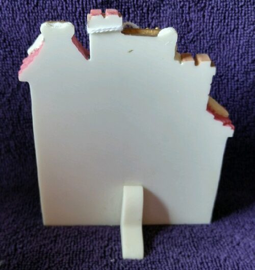 A white picture frame with a pink and brown design.