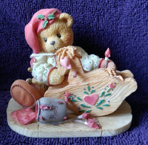A teddy bear sitting on top of a wooden boat.