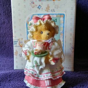 A bear in a dress holding a plate