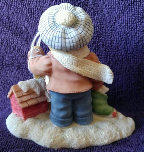 A figurine of someone with a hat and scarf on.