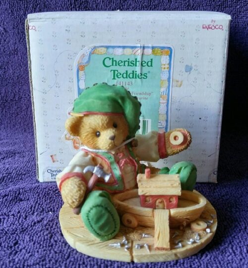 A teddy bear sitting on top of a wooden toy.