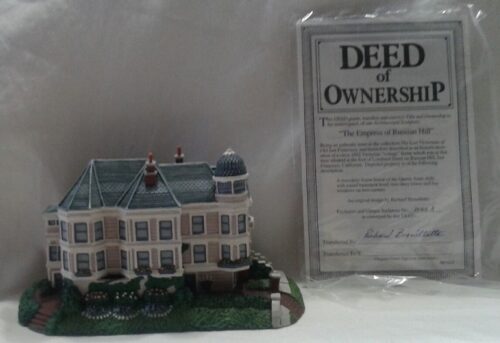 A miniature house with deed of ownership attached.