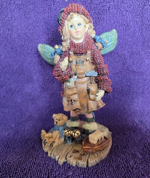 A figurine of an angel with teddy bears.