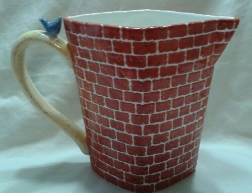 A red brick mug with a bird on the handle.