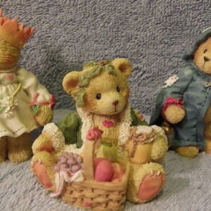 A group of four teddy bears sitting on top of a rug.