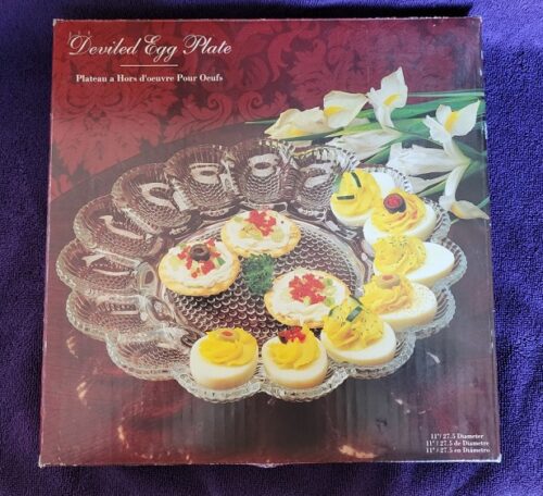 A box of deviled egg plates on top of purple cloth.