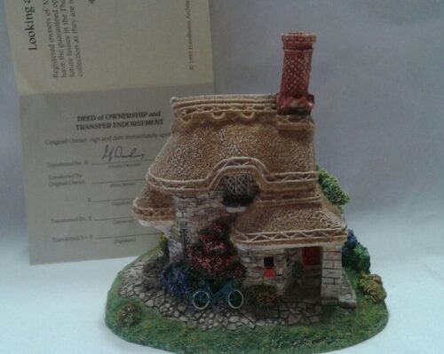 A miniature of a house with a train on the tracks.