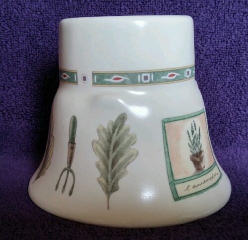 A white vase with some green plants on it