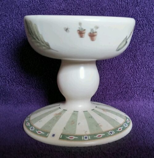 A white pedestal with green and brown designs.
