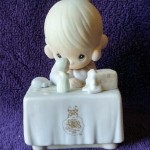 A small figurine of a baby sitting on top of a table.