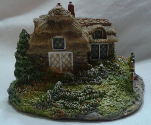 A small model of a house with thatched roof.