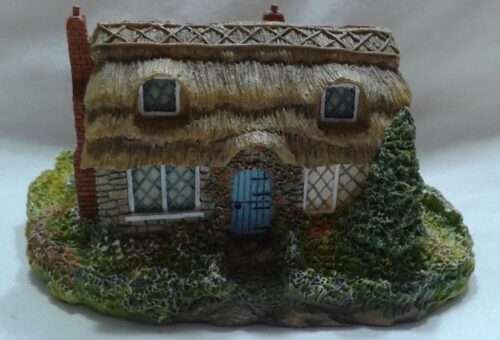 A small house with a thatched roof and blue door.
