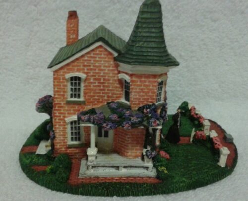 A small model of a house with trees and flowers.