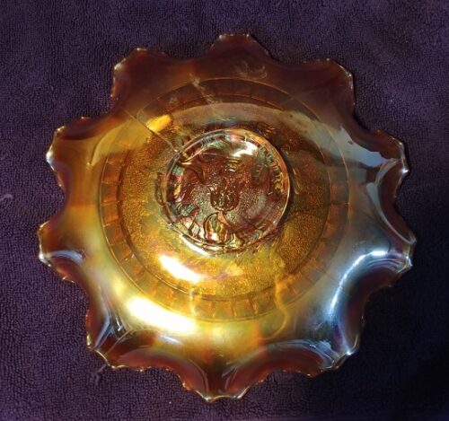 A bowl with a gold rim and a brown background