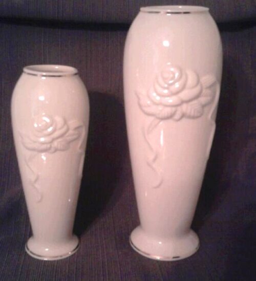 Two white vases with a rose design on them.