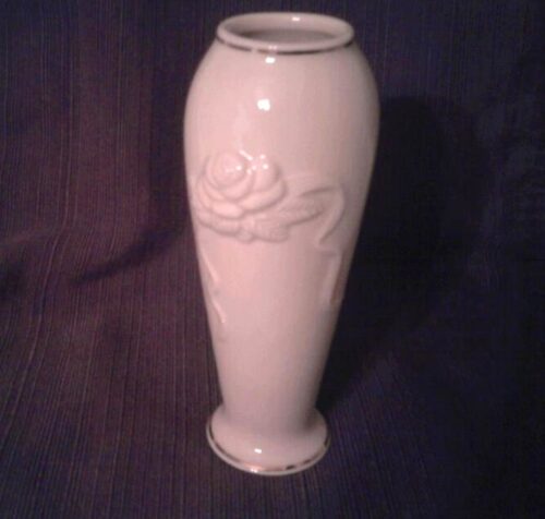 A white vase with a flower design on it.