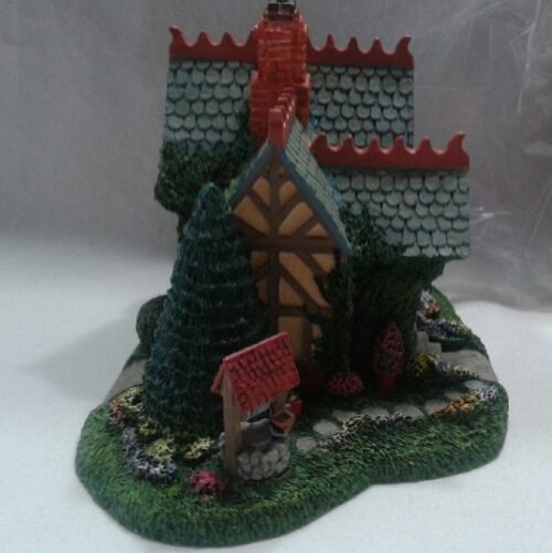 A small castle with a red roof and green walls.