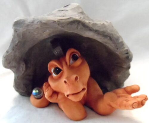 A clay sculpture of an animal with a rock hat.