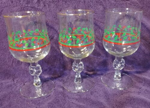 Three wine glasses with a christmas design on them.