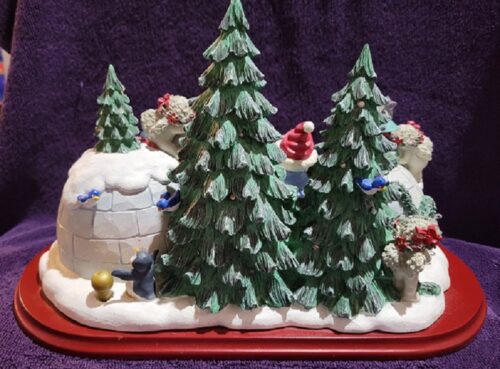 A christmas tree scene with snow and trees.