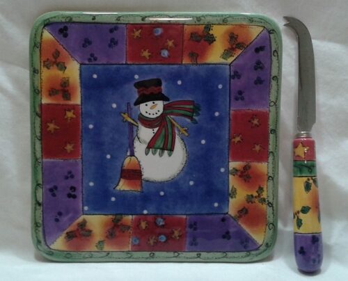 A square plate with a snowman on it and a knife.