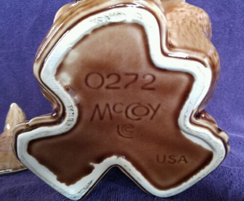 A brown and white cookie jar with the words " mccoy " on it.